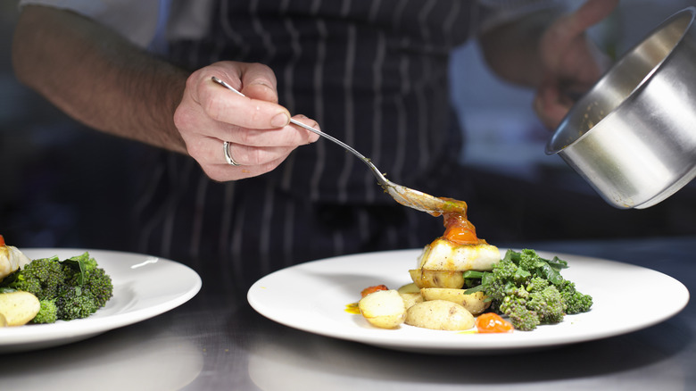 chef plating dish with fingerling potatoes