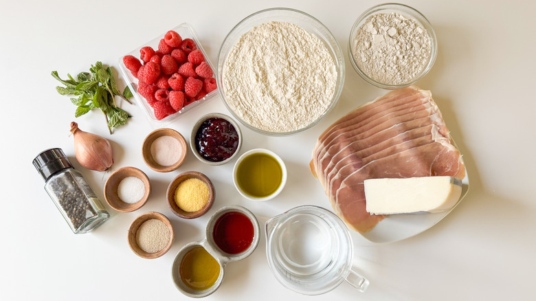 Rye flatbreads with prosciutto and raspberry ingredients on countertop