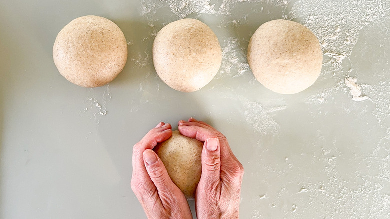 Flatbread dough balls on floured work surface