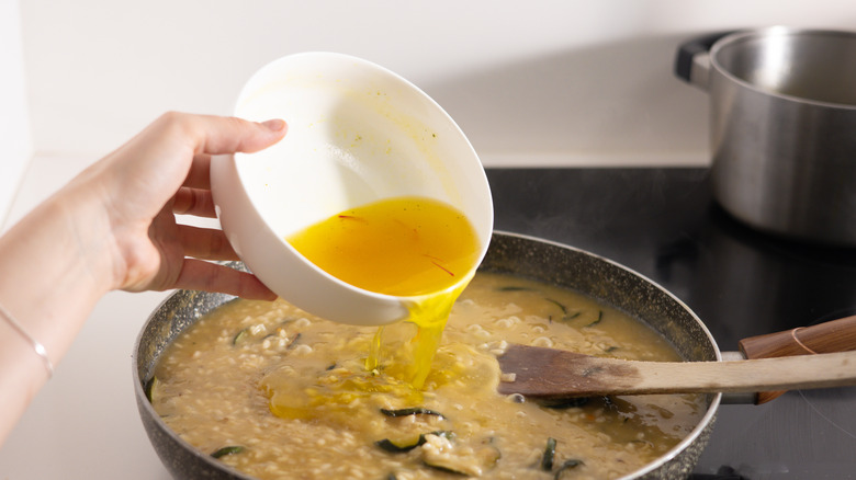 saffron risotto going into pan