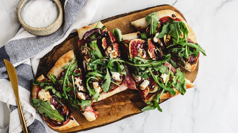 flatbread on cutting board with knife and napkin