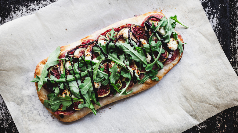 baked flatbread with fresh arugula and balsamic reduction