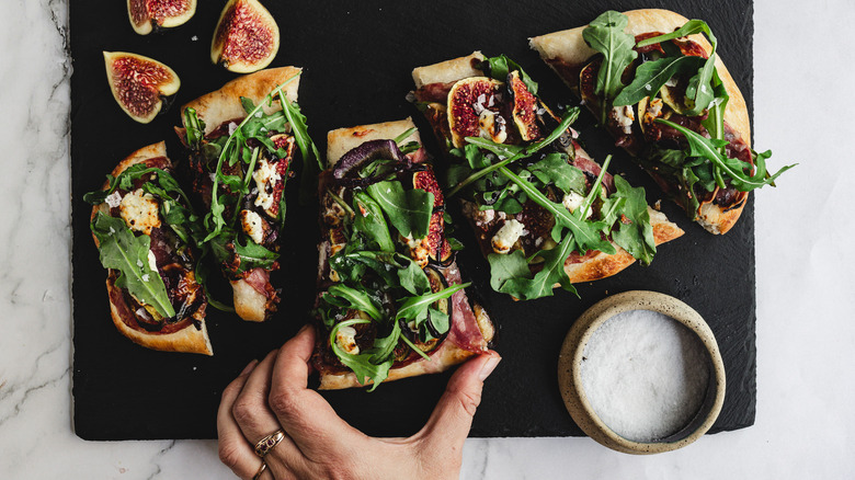 hand grabbing a slice of flatbread