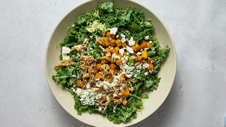 adding salad ingredients to bowl