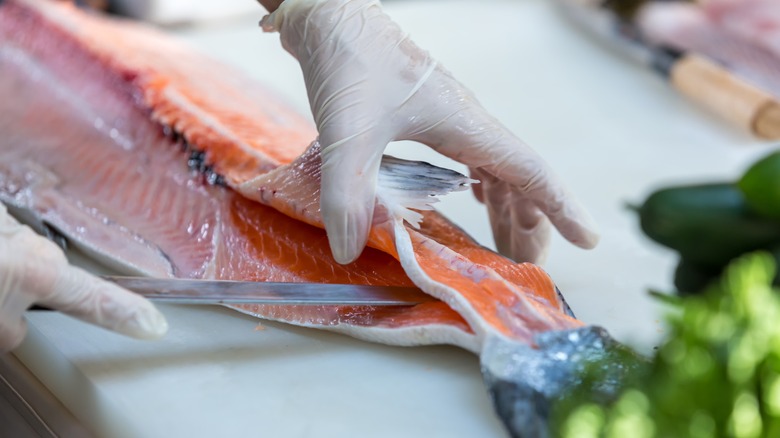 Hand slicing a salmon fillet