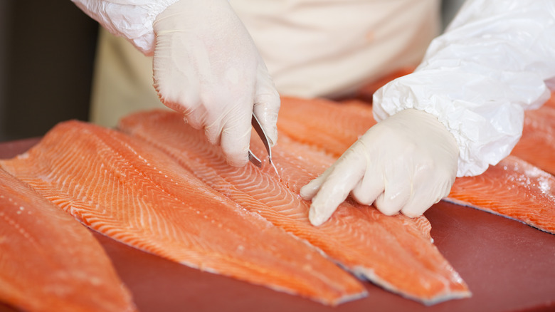 worker processing raw salmon