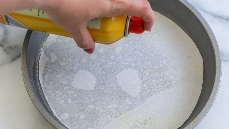 hand spraying cake pan