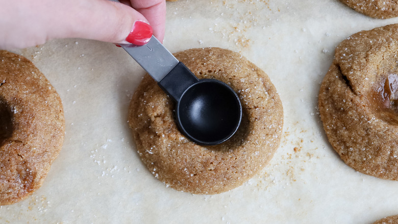hand squishing cookie with spoon