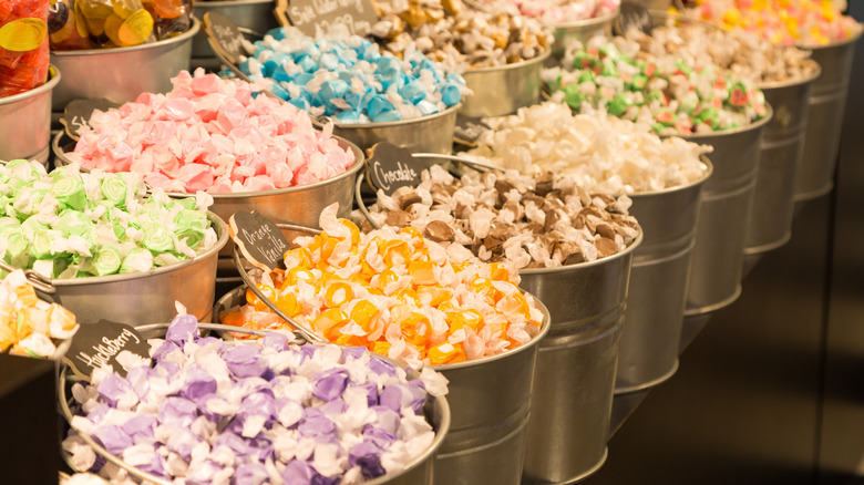 Aluminum buckets of taffy flavors line store shelves