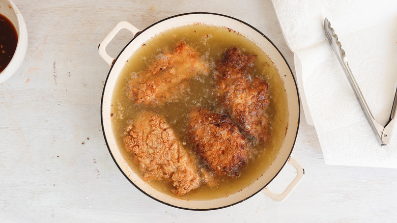 breaded chicken frying in oil