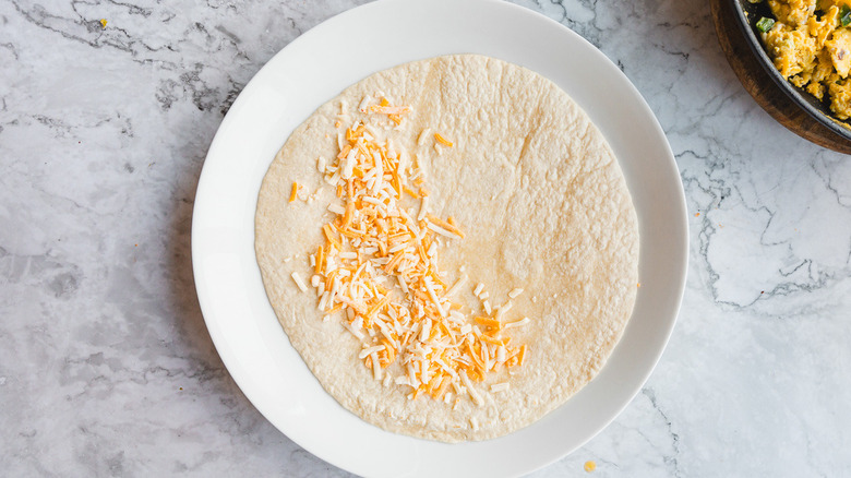 Tortilla with cheese on white plate