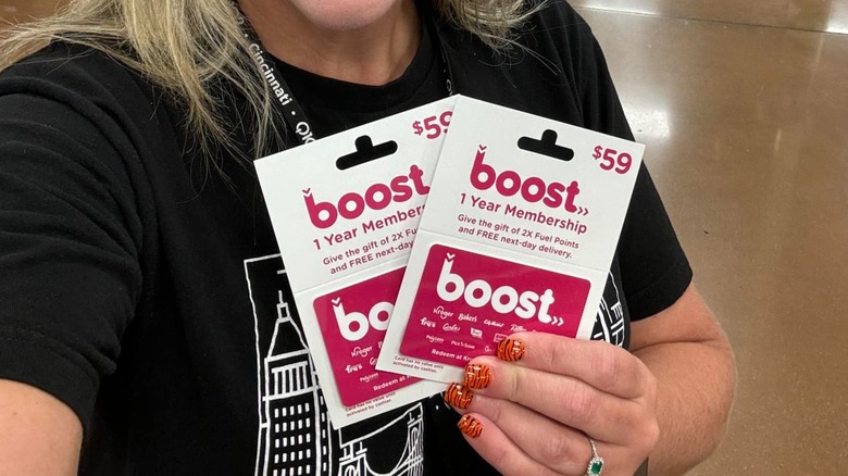 woman holding Kroger Boost membership cards