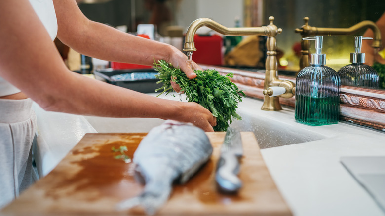 cook preparing fish and greens