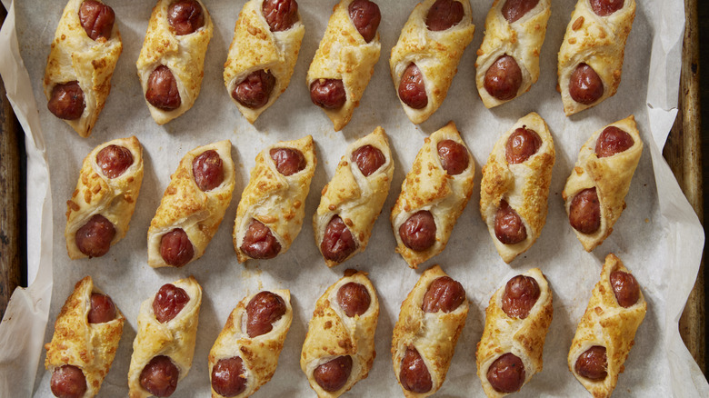 pigs in a blanket laid in rows on a sheet pan