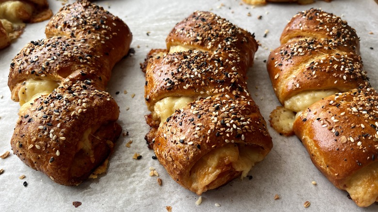 three ham and cheese bear claws on a baking sheet