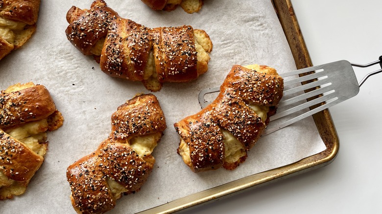 Spatula lifting bear claw off a baking sheet