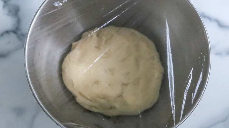 dough in bowl covered with plastic