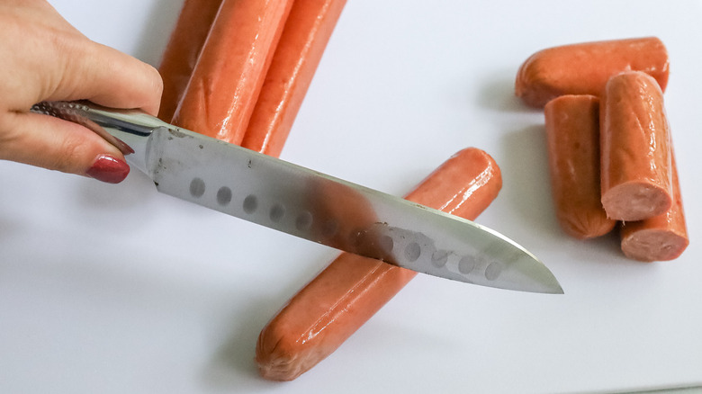 knife cutting sausage in half