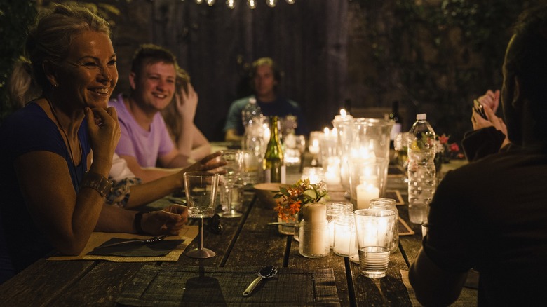 People smiling at a candlelit dinner party