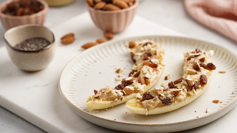 halved bananas with nuts and butter toppings