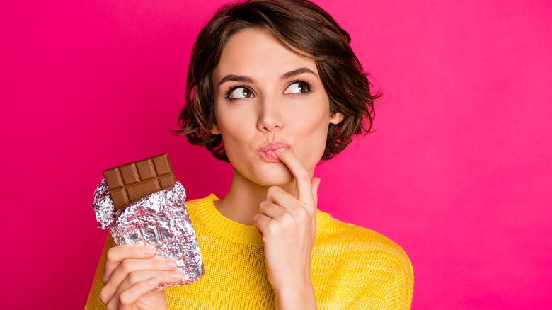 Woman tasting finger with chocolate bar