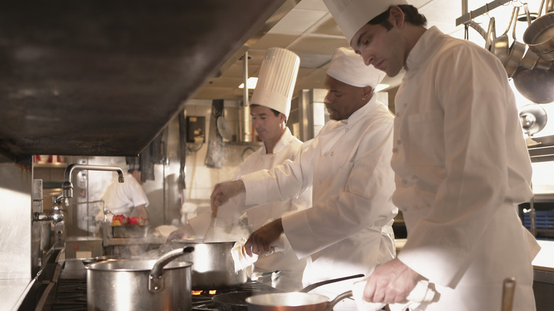 Three people cooking in a restaurant.