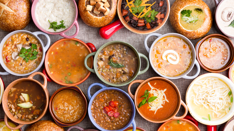 numerous different types of soup in pots and bread bowls