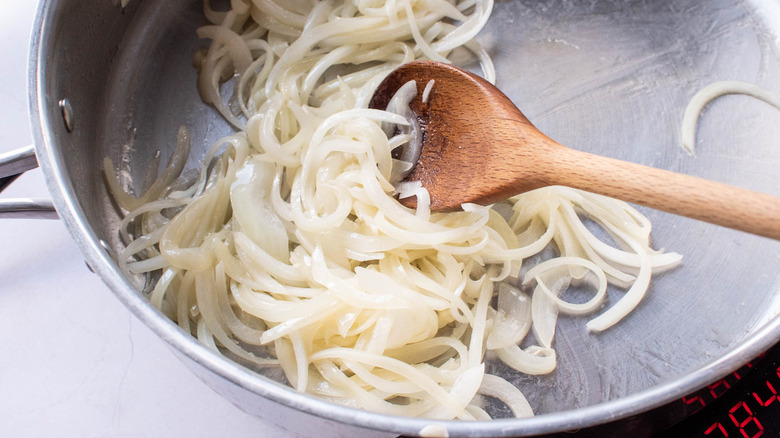 sliced onions frying in pan