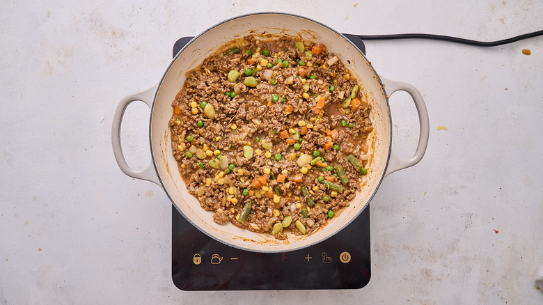 adding vegetables to skillet