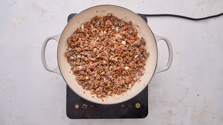 mixing tomato paste into skillet