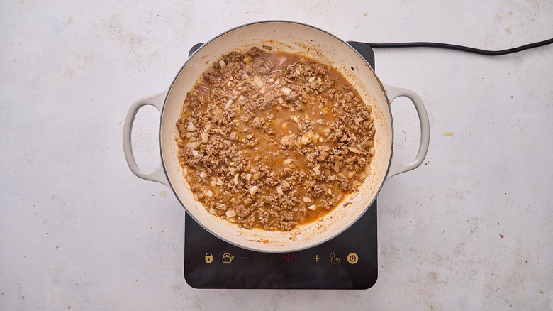 stirring broth into skillet