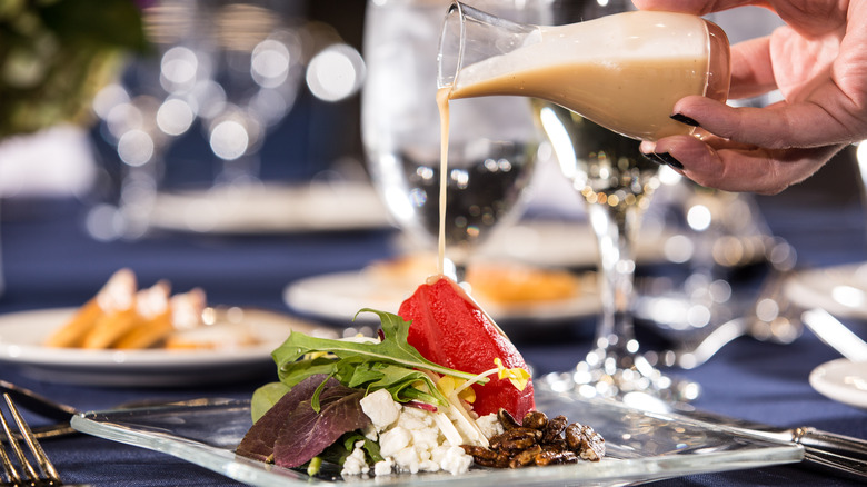 pouring dressing on a salad