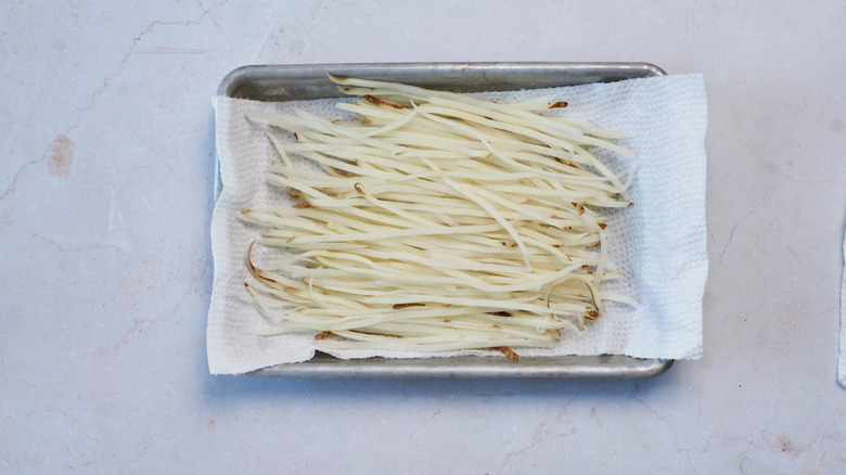 raw fries on baking sheet
