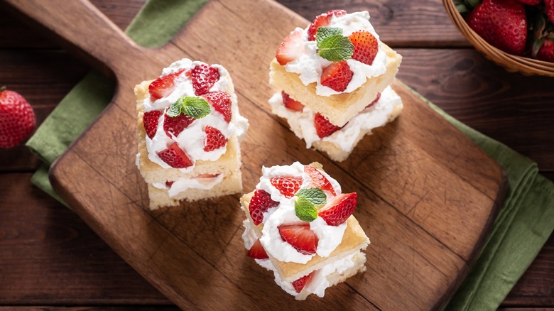 Three slices of strawberry shortcake on a board