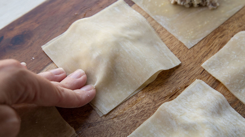 fingers pressing down ravioli square