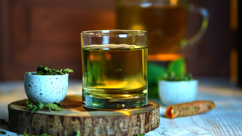 green tea in glass on board