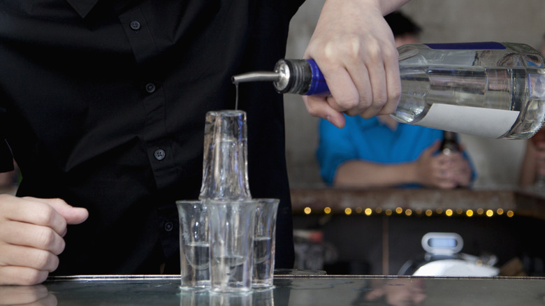 Liquor poured over shot glasses