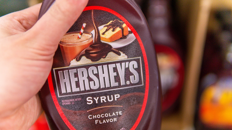 Person holding Hershey's chocolate syrup