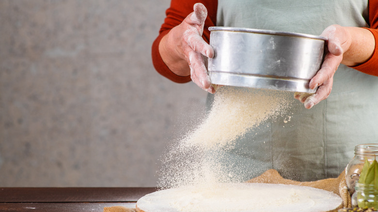 baker sifting flour