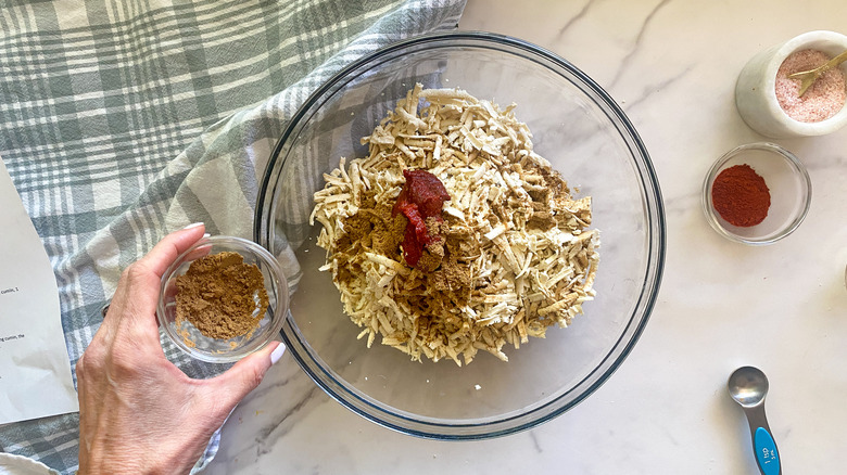 adding cumin to bowl