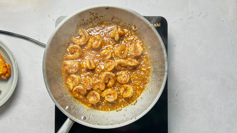 shrimp and marinade cooking in metal skillet