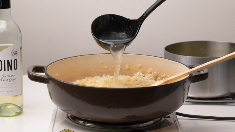 pouring stock into risotto