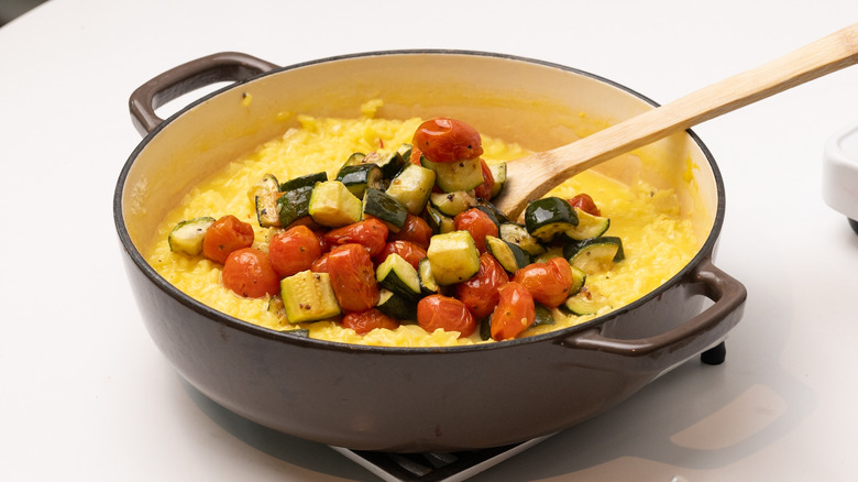 adding roasted vegetables to risotto