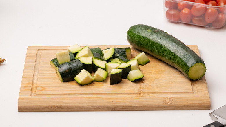 slicing zucchini on chopping board