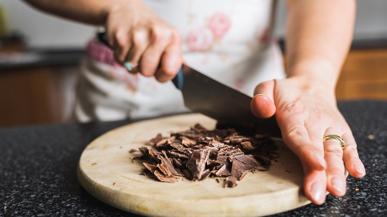 Chopping chocolate on wooden board