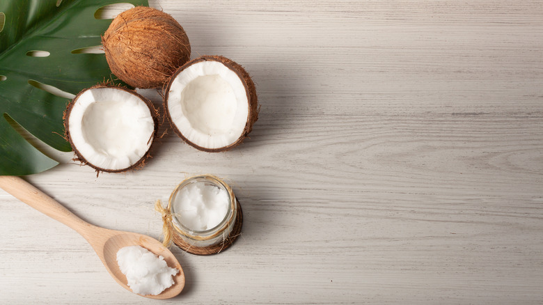 jar of coconut oil and pieces of coconut with spoon