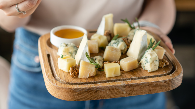 Person holding a cheese plate