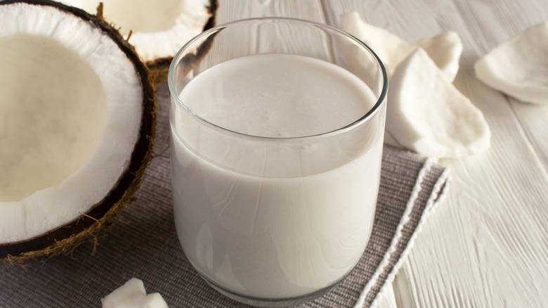 Coconut milk next to coconut pieces 