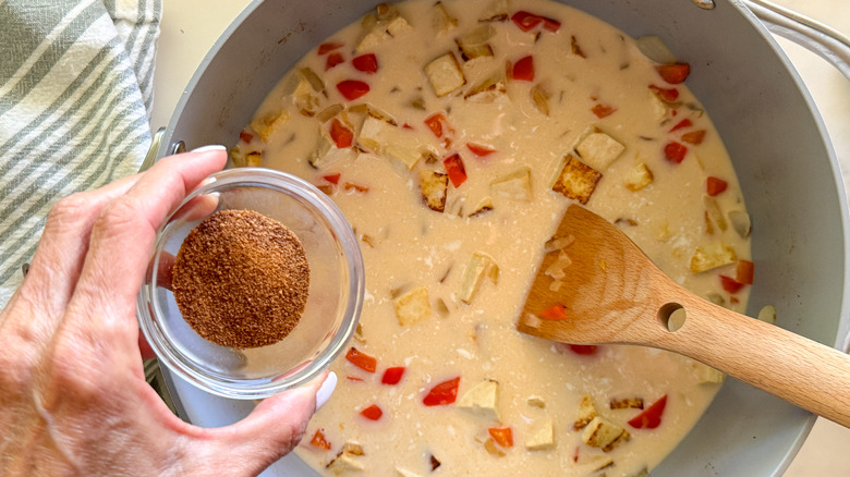 hand adding sugar to pot