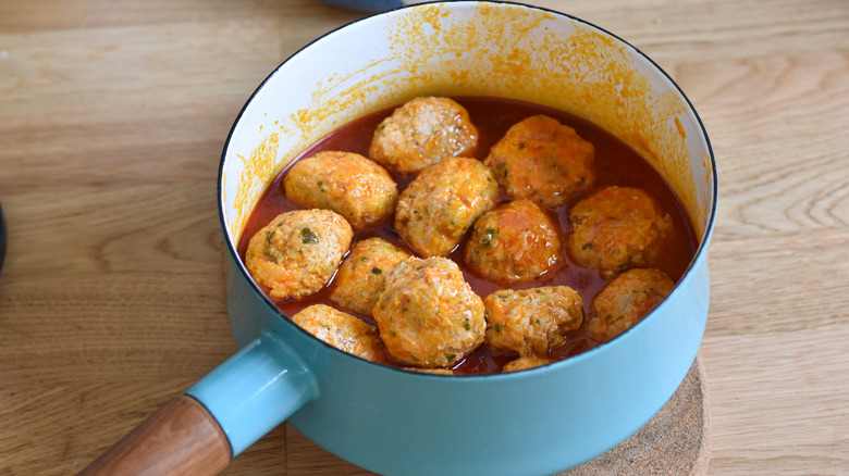 Pot of simmering saucy meatballs